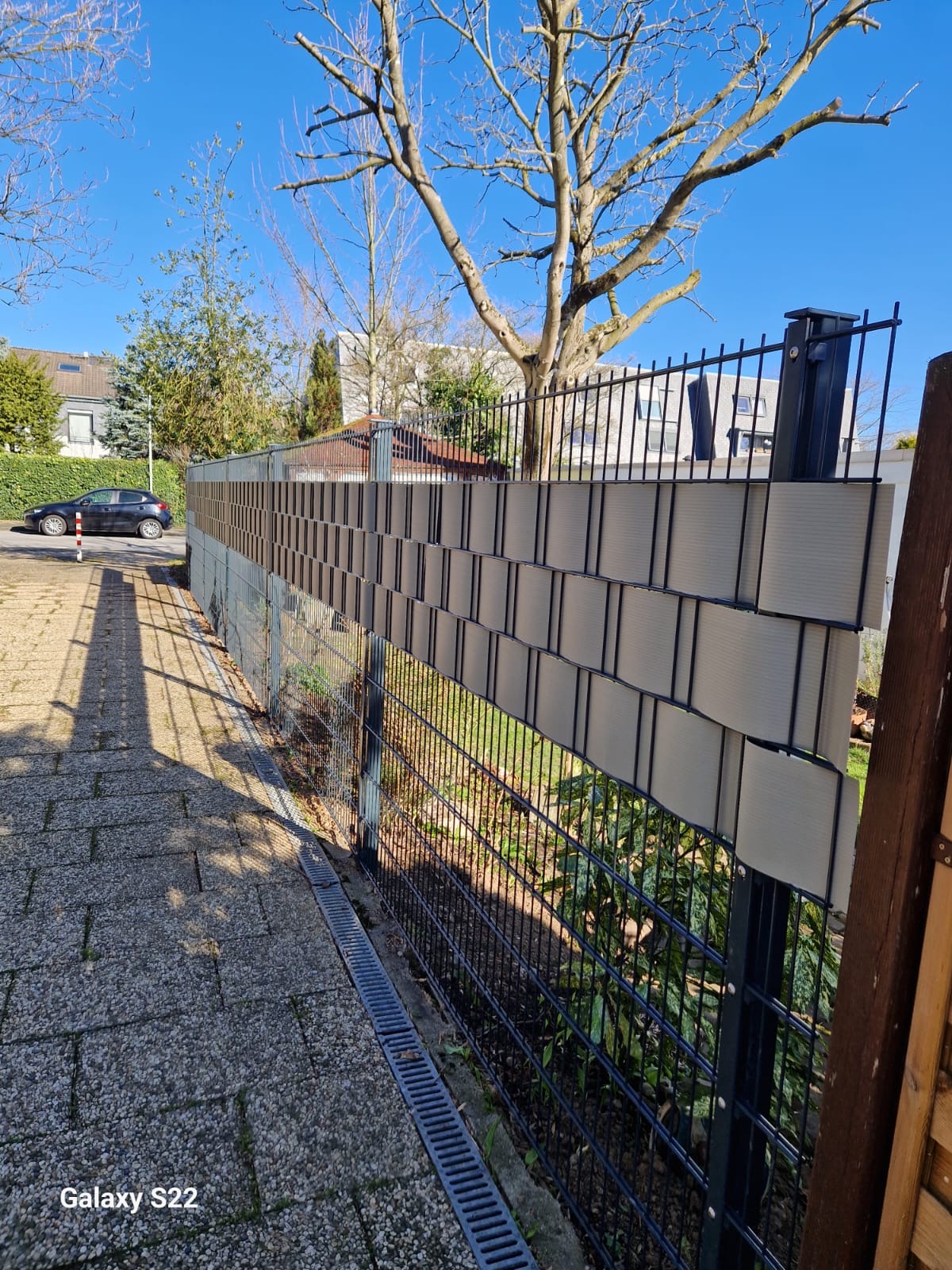 Zaunbau Hilden Nachher – Doppelstabmattenzaun mit Sichtschutz Nachher: Moderner Doppelstabmattenzaun mit Sichtschutzstreifen in Hilden – Zaunbau von Basri GaLaBau